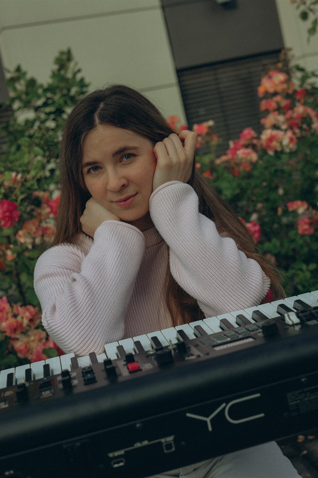 Nadiia Zhurba lächelnd am Keyboard im Garten